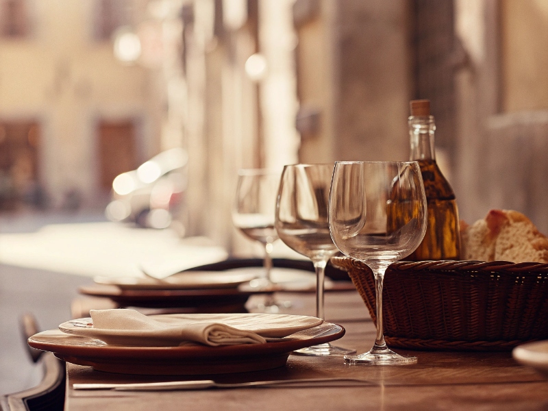 Tavola apparecchiata in trattoria con bicchieri e pane